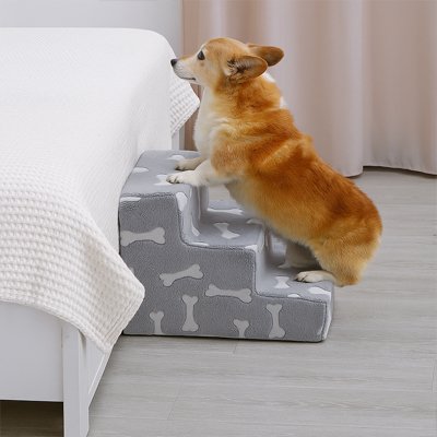 ComfortStep un petit chien beige et blanc monte l'escalier pour chien trois marches